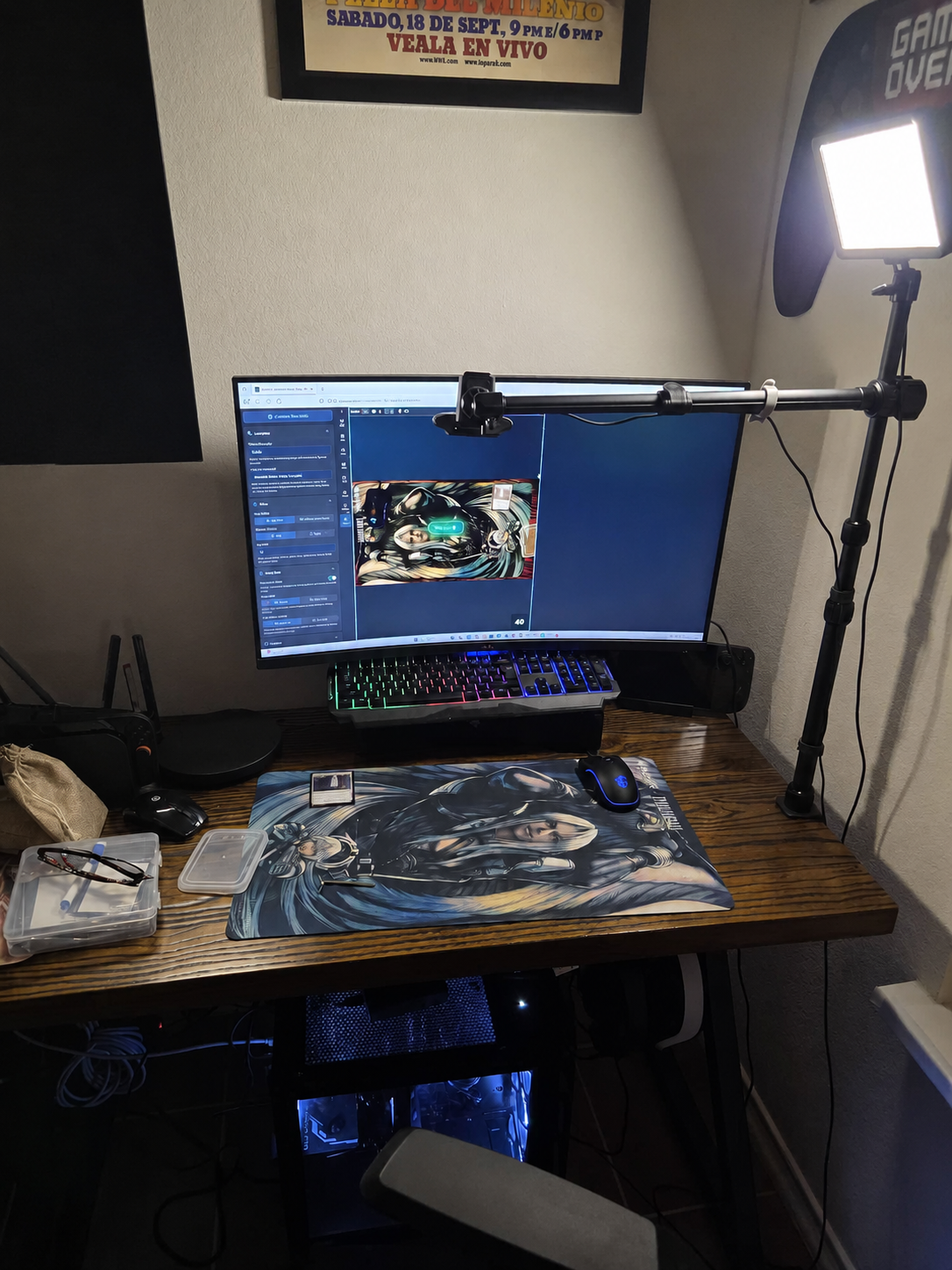 Montaje de webcam con brazo de cámara sobre un playmat de Magic, pantalla y lámpara junto al escritorio